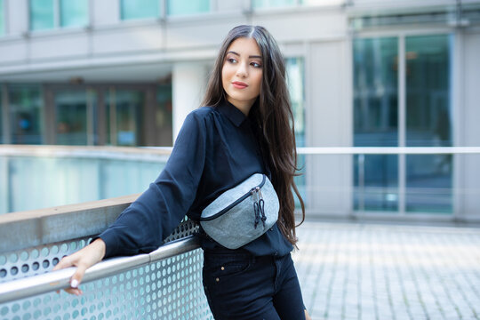 trend fashion teenage girl look to side and pose with her grey noname fanny pack at shoulder while being confident with this statement casual fashion piece