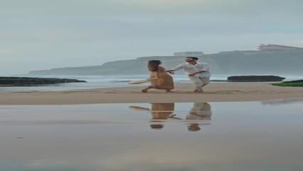 Sensual couple embracing beach at cloudy sky. Man twirling woman dance vertical