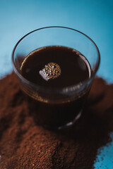 Black coffee and ground coffee on a blue background. Breakfast concept.