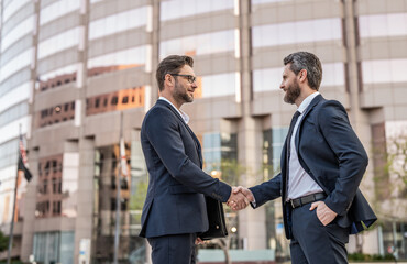 two businessmen deal with handshake outdoor, copy space. two businessmen in suit deal
