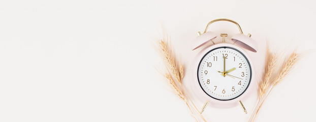 Alarm clock with wheat, end of daylight saving time in autumn, winter time changeover
