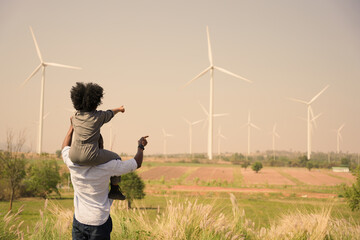 African american family in the community with wind generators turbines, Wind turbines are...