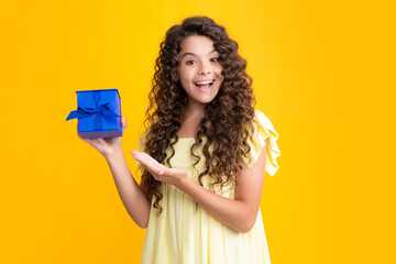 Happy teenager portrait. Child with gift present box on isolated background. Presents for birthday, Valentines day, New Year or Christmas. Smiling girl.