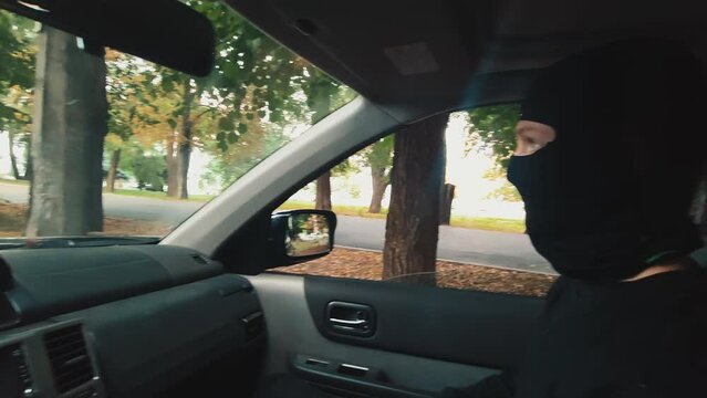 Robbers in car, thug in a balaclava. Robbery, abduction, rapine,  crime, theft. 