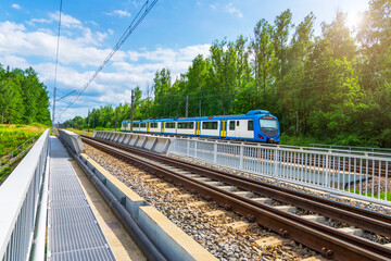 Railway traction. Passenger train on the railway bridge.