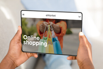 Man shopping online via digital tablet, choosing new clothes at store, sitting at home, enjoying...