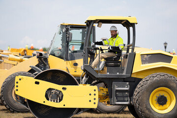 construction man worker at construction heavy machinery or roadwork machine equipment outside