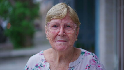 Close-up face of a senior woman looking at camera smiling. Portrait of an elderly Caucasian female person in 80s, old age wisdom concept