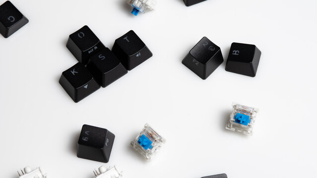 Keycaps and Keyswitch for Mechanical Keyboards Scattered on White Background
