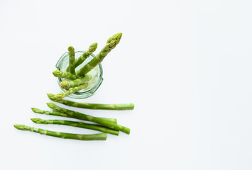 Top view crisp asparagus officinalis green sprouts from grocery store. White table . Asparagus...