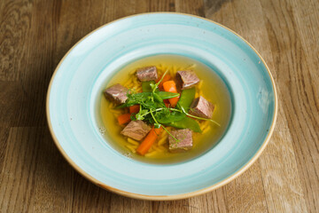 Top Down View of Beef Soup in a Plate on a wooden table