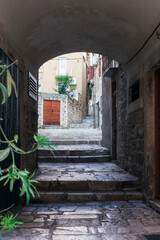 Arch and narrow street in old town of Sibenik, Croatia. Summer vacation travel background