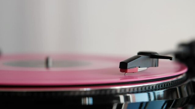 close up angle of a rose vinyl record spinning on turnable