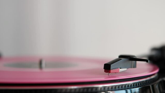 close up of a rose vinyl record spinning on turnable