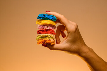 Marketing banner with mix of sweet multicolored blanks of macaron broken in half in female hands