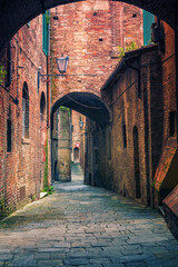 Narrow street in old town Siena Tuscany, Italy - obrazy, fototapety, plakaty