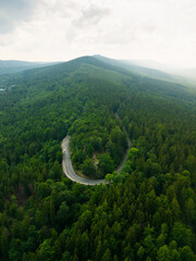Winding mountain asphalt road. Forest around, mountains in the background. Jizera Mountains. Szklarska Poreba. Lower Silesia.