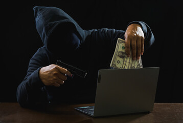 Hacker spy man wearing a black shirt, sitting on a chair and a table, is a thief, hands holding...