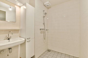 a bathroom with a sink and mirror above the shower stall in white tiled wallpapered room next to it