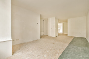 an empty room with white walls and green flooring on the right, there is a door in the middle