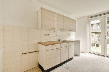 a kitchen with white tiles and wood counter tops on the counters in front of the door to the outside patio