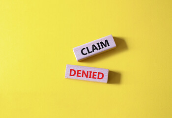 Claim denied symbol. Wooden blocks with words Claim denied. Beautiful yellow background. Business and Claim denied concept. Copy space.