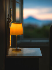 Lit old lamp on a side table at twilight. Enchanting photograph