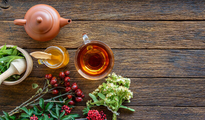 herbal medicine composition linden herb tea, honey, rose hips and goji berries on a old wooden table 