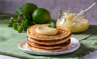 Whole grain flour fritters served with lime curd on a light background. Rustic style.