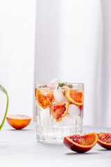 Cold refreshing summer drink with red oranges and thyme