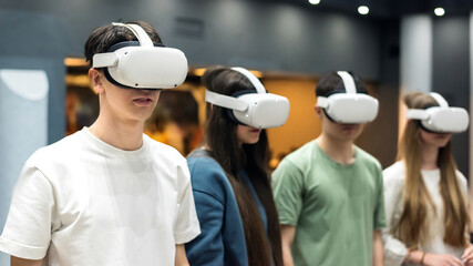 Four teenagers wearing VR equipment