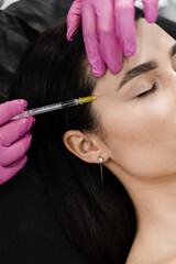 Cosmetologist injecting facial biorevitalization for moisturizing effect. Close-up facial biorevitalization for increasing skin tone, reducing wrinkles, and strengthening oval of the face.
