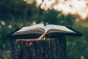 Open bible at sunset in nature, christian concept