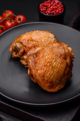 Delicious juicy chicken thighs baked with salt, spices and herbs in a ceramic plate