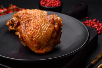 Delicious juicy chicken thighs baked with salt, spices and herbs in a ceramic plate