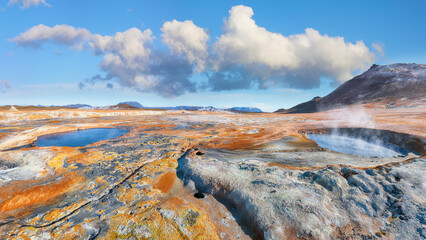 Breathtaking boiling mudpots in geothermal area Hverir and cracked ground around. - obrazy, fototapety, plakaty