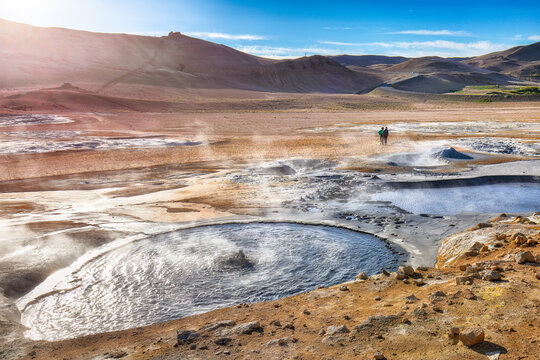 Breathtaking boiling mudpots in geothermal area Hverir and cracked ground around.