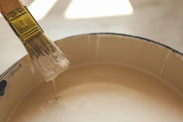 Paint brush resting on paint tin viewed from above