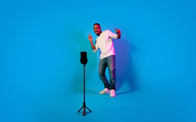 Charismatic stylish african guy performing in front of cell phone