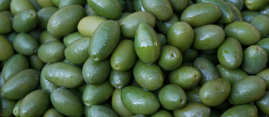 Green olives close-up on the market. Banner