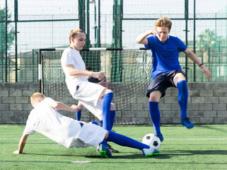 Young football player doing tackle to take ball away © JackF