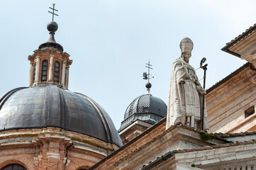 Urbino, Italy - 2023, May 5: Saint Agostino statue, on the Santa Maria Assunta cathedral roof. In...