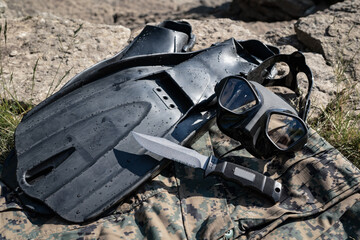 Diving equipment of a combat swimmer, a diving mask, fins and a marine's knife.