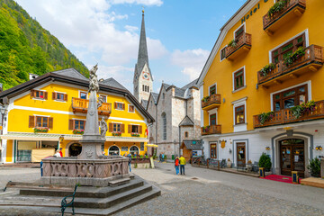 The colorful Market Square or Marktplatz with a view of the Evangelical Church of Hallstatt, in the...