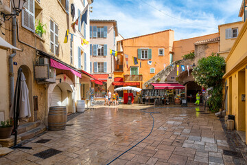Morning at a small square of shops and cafes in the center of the Old Town section of Saint-Tropez, France, a popular resort on the French Riviera. - obrazy, fototapety, plakaty