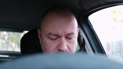 A man falls asleep at the wheel of a car. Travel fatigue.