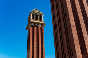 Fototapeta na wymiar Two Venetian towers in Barcelona, made of exposed brick, built during the universal exhibition of 1929.