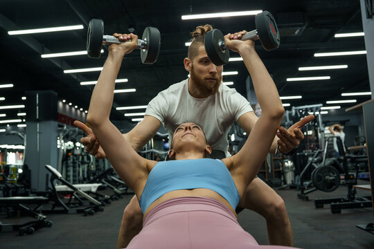 A fitness instructor and his client hit the gym together, pushing each other to new heights as they sweat it out and work towards their fitness goals.