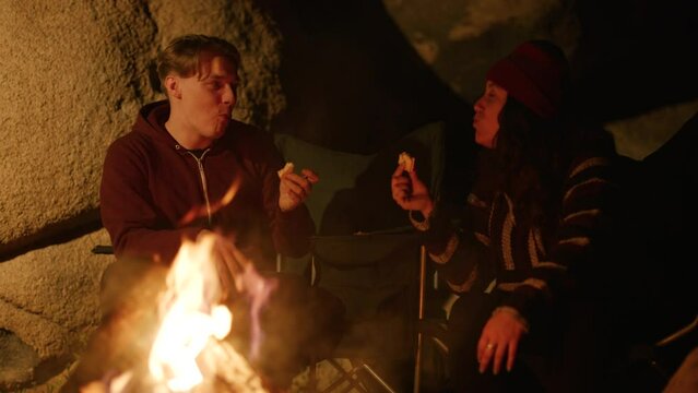 Boy and girl enjoying Marshmello and having fun by the campfire on campsite on the Fourth of July. Joshua tree California USA High quality 4K footage
