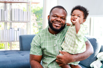 Portrait of a happy African American father and son in the house. Family concept.